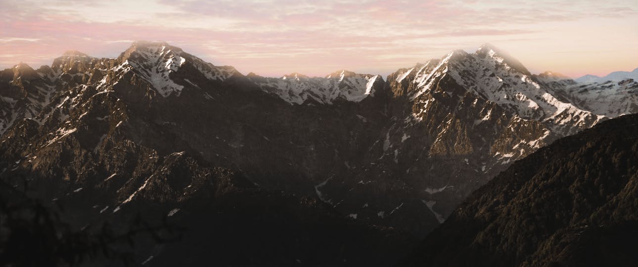 Breathtaking view of snow-covered mountains with a vibrant sunset sky.