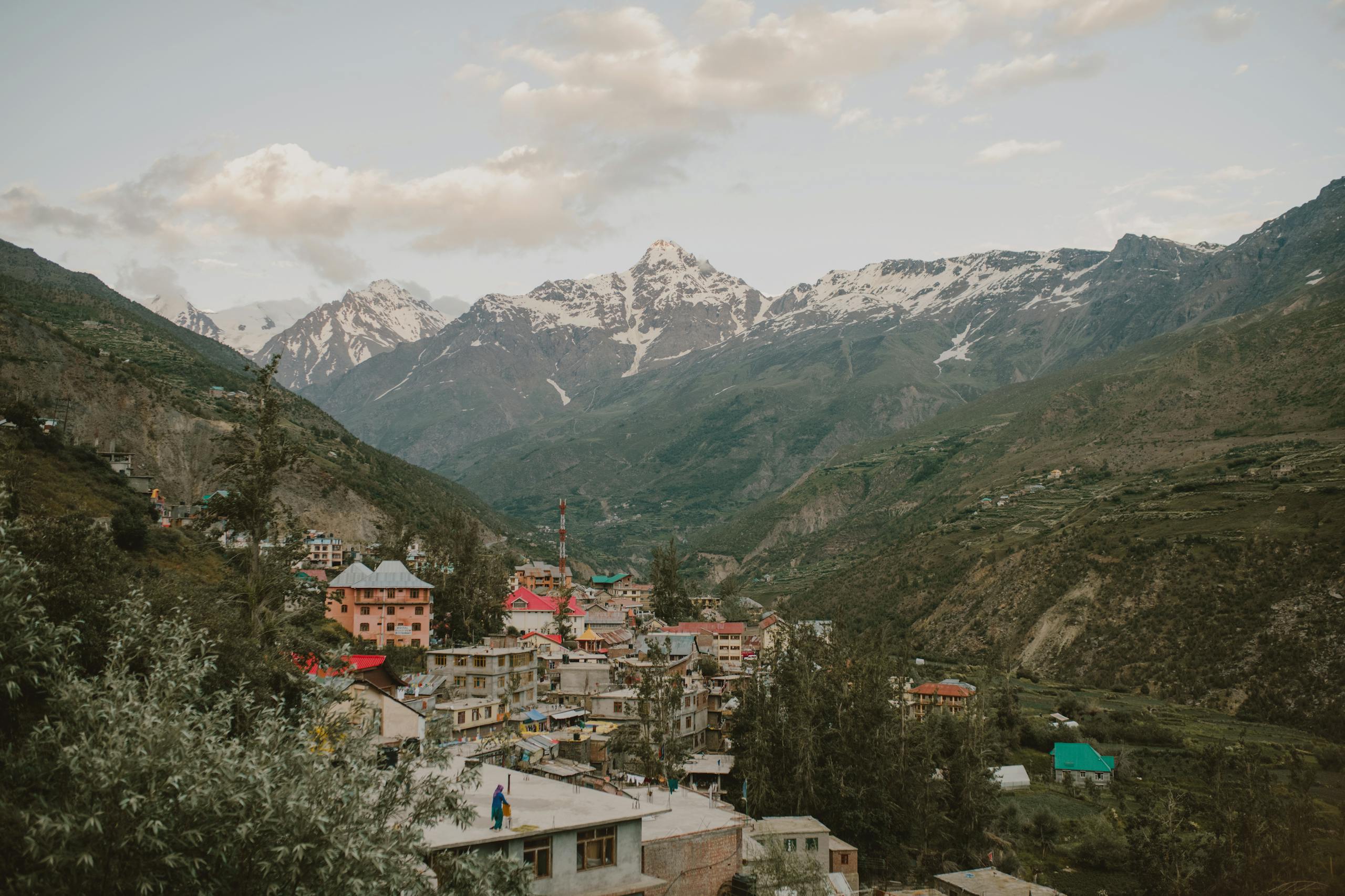 Picturesque village nestled in the Himalayan mountains of Manali, India, during a calm day.